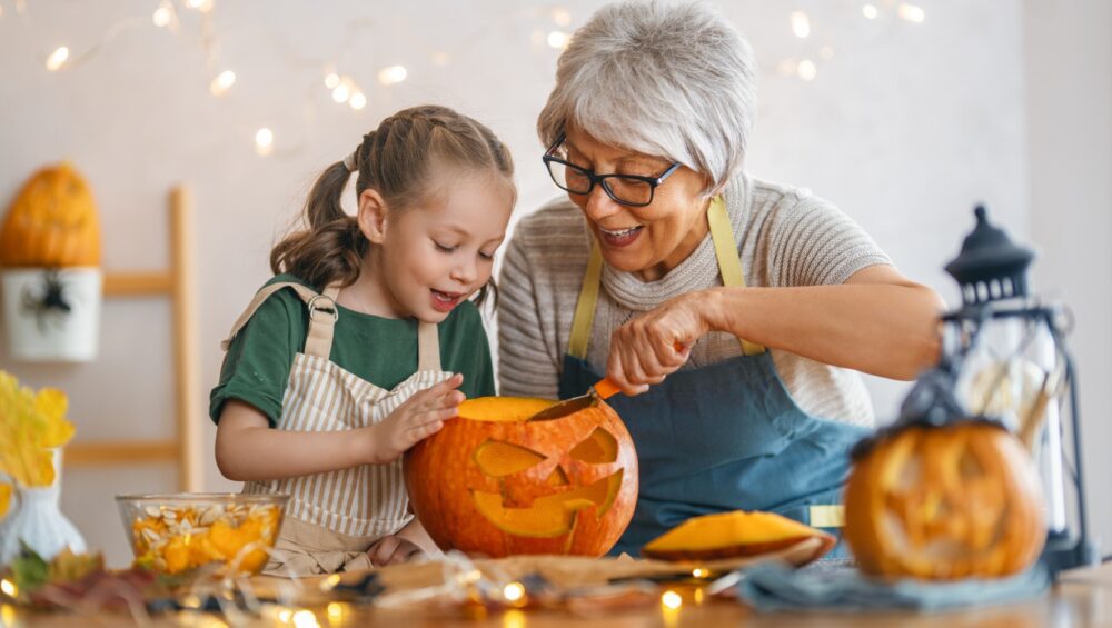 Grandma and granddaughter carving a pumpkin