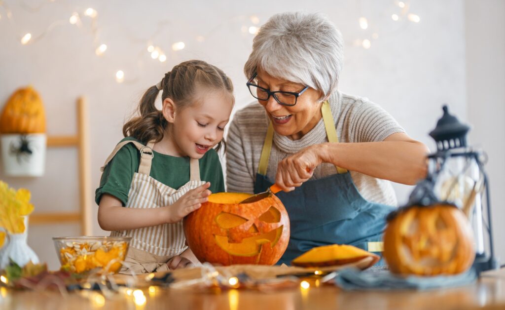 Grandma and granddaughter carving a pumpkin