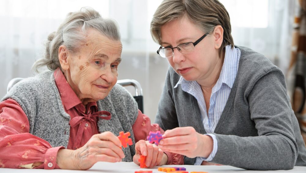 Middle-aged woman playing a game with a senior woman