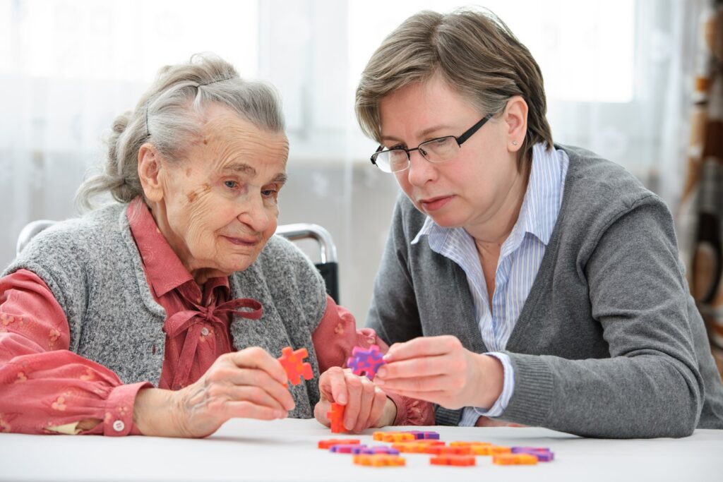 Middle-aged woman playing a game with a senior woman