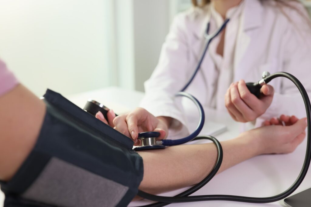 Nurse checking blood pressure with blood pressure cuff