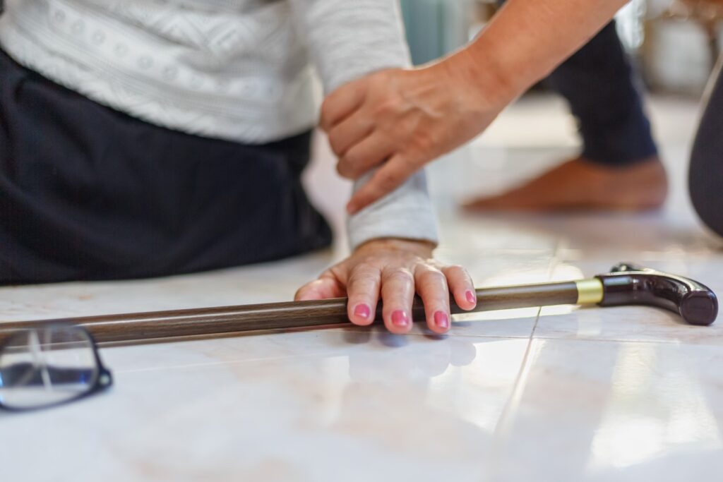 A caregiver coming to help a senior woman up after her fall