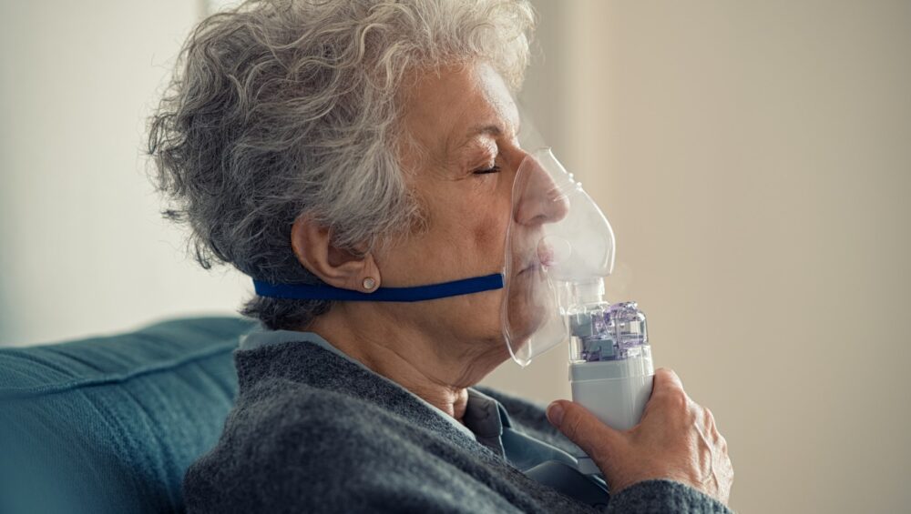Elderly woman using a nebulizer.
