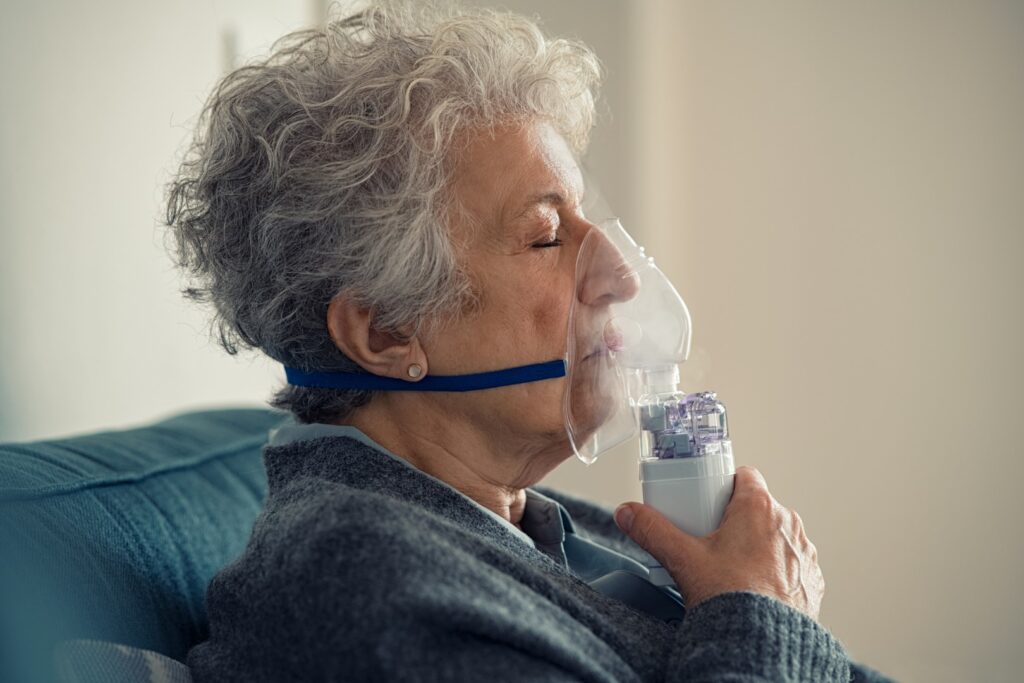 Elderly woman using a nebulizer.