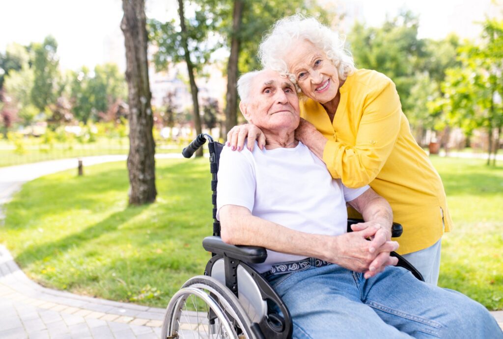 Senior woman hugging senior man in wheelchair