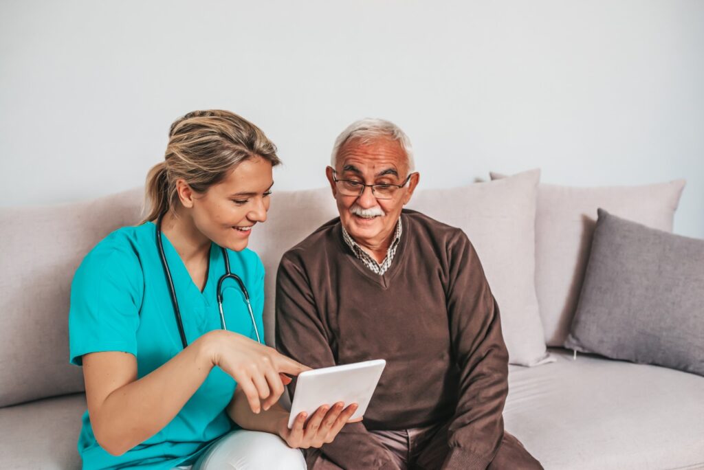 Assisted living resident with caregiver using a tablet computer