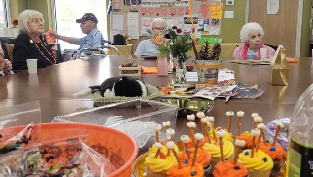 Close-up of Halloween treats on a table with senior citizens in the background.