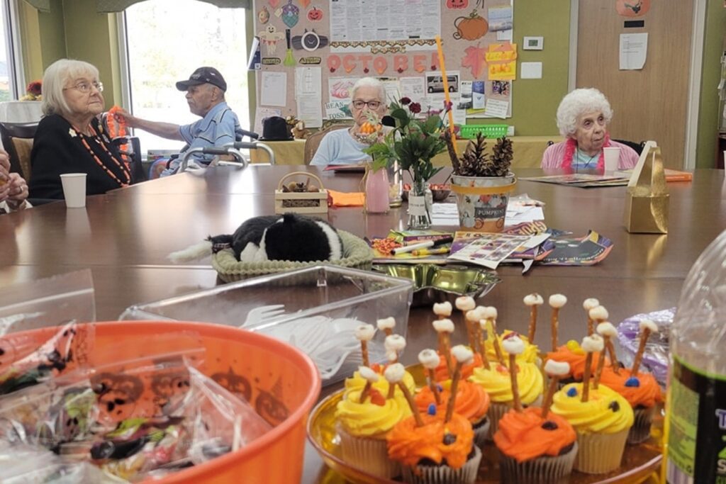 Close-up of Halloween treats on a table with senior citizens in the background.