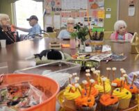 Close-up of Halloween treats on a table with senior citizens in the background.