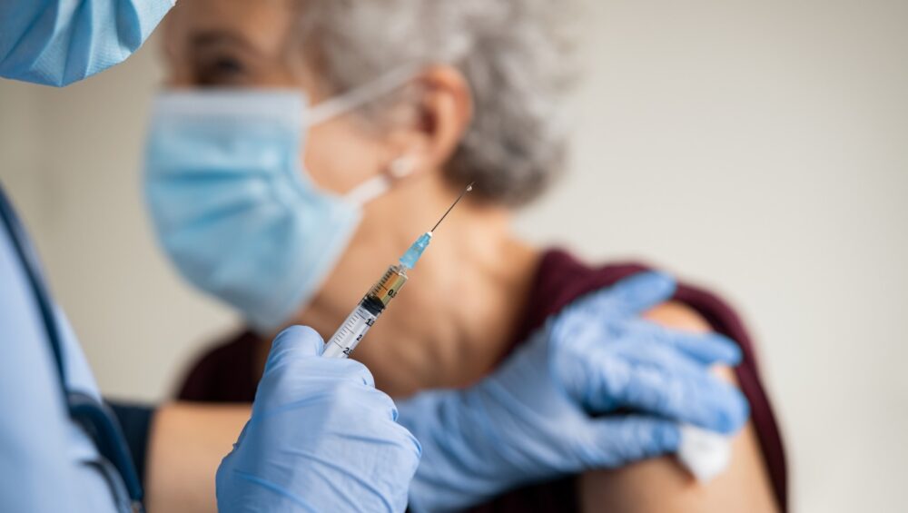 Elderly woman receiving a pneumonia vaccine.