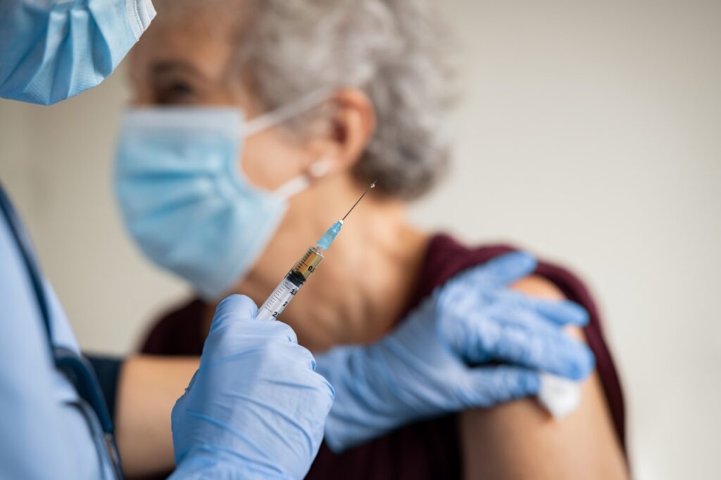 Elderly woman receiving a pneumonia vaccine.