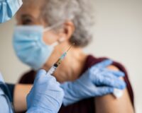 Elderly woman receiving a pneumonia vaccine.