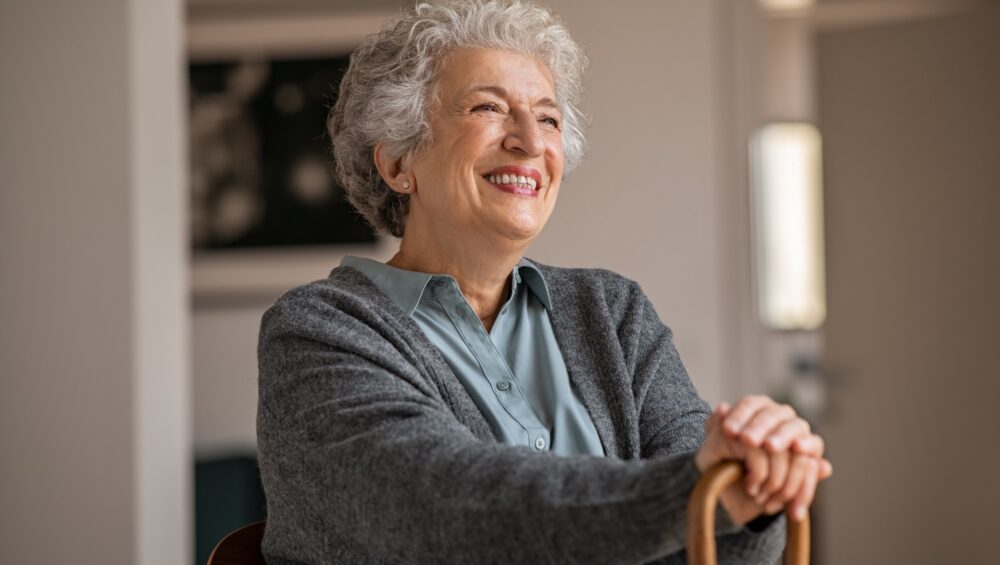 Happy smiling senior woman with cane.