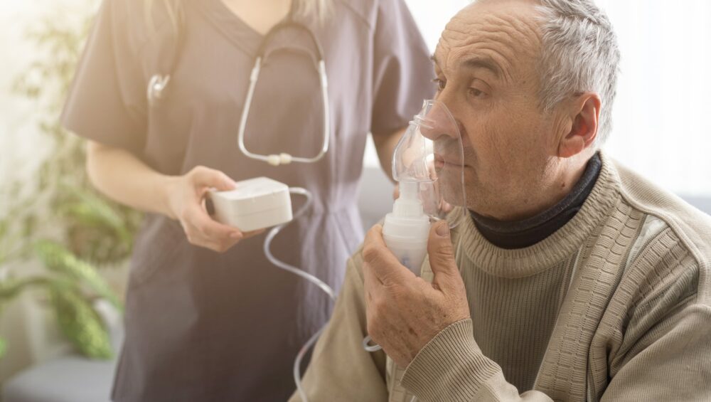 Elderly Senior Man nursing care wear oxygen inhaler device for helping breath respiratory. Oxygen Concentrator portable