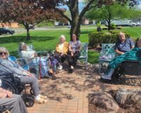 A group of Manoogian Manor residents enjoying sitting outside.