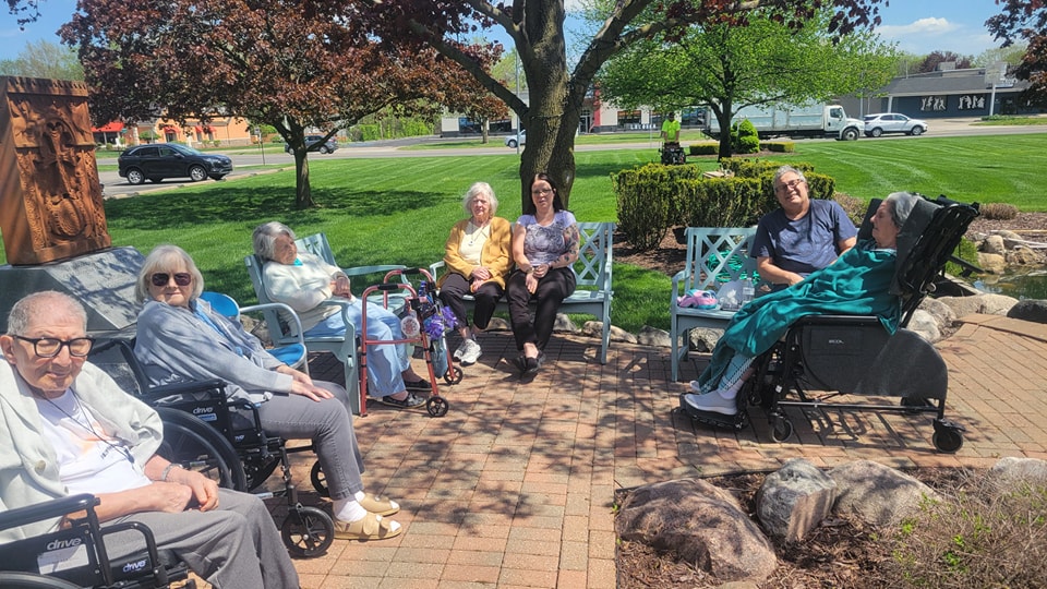 A group of Manoogian Manor residents enjoying sitting outside.