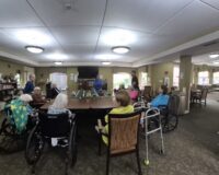 Residents of Manoogian Manor playing games around a large table.