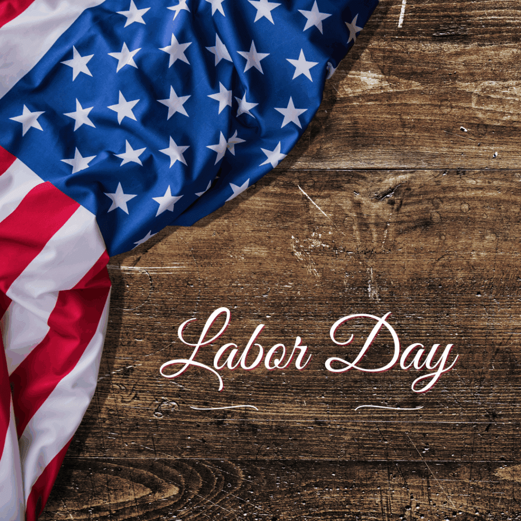Close-up of an American flag draped over a rustic wooden surface with the words 'Labor Day' elegantly written in white script.