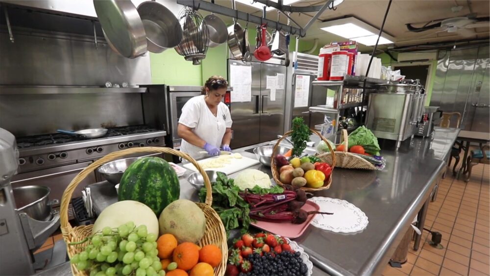 Manoogian Manor kitchen full of fresh vegetables and cooks.